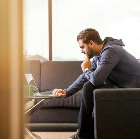 Lachende ondernemer aan het werk achter zijn laptop