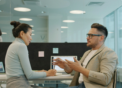 Twee mensen in gesprek aan een bureau